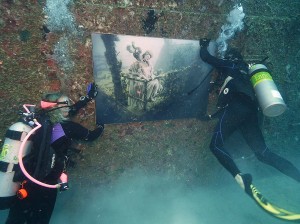 Divers install a photo illustration on the Gen. Hoyt S. Vandenberg, a 523-foot-long former U.S. Air Force missile-tracking ship that was scuttled in 2009 as an artificial reef seven miles south of Key West, Fla., in the Florida Keys National Marine Sanctuary. The print, encased in pleixglass, is one of a dozen created by Austrian art photographer Andreas Franke that are part of an underwater art gallery that is to remain on the ship through early August 2016. FOR EDITORIAL USE ONLY (Joe Berg/Florida Keys News Bureau/HO)